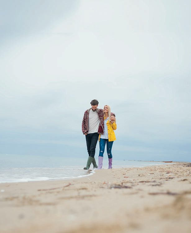 Man en vrouw wandelen op het strand